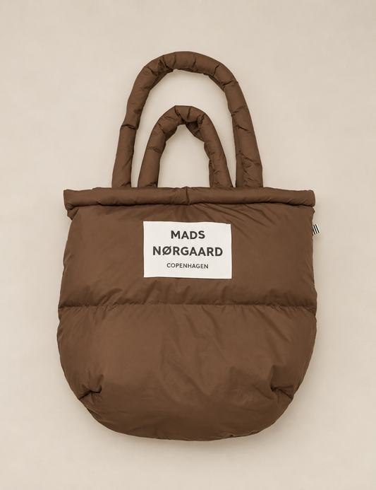 Light Ripstop Pillow Bag in cocoa brown, an oversized lightweight puffer tote bag with dual carrying handles and recycled polyester fabric.